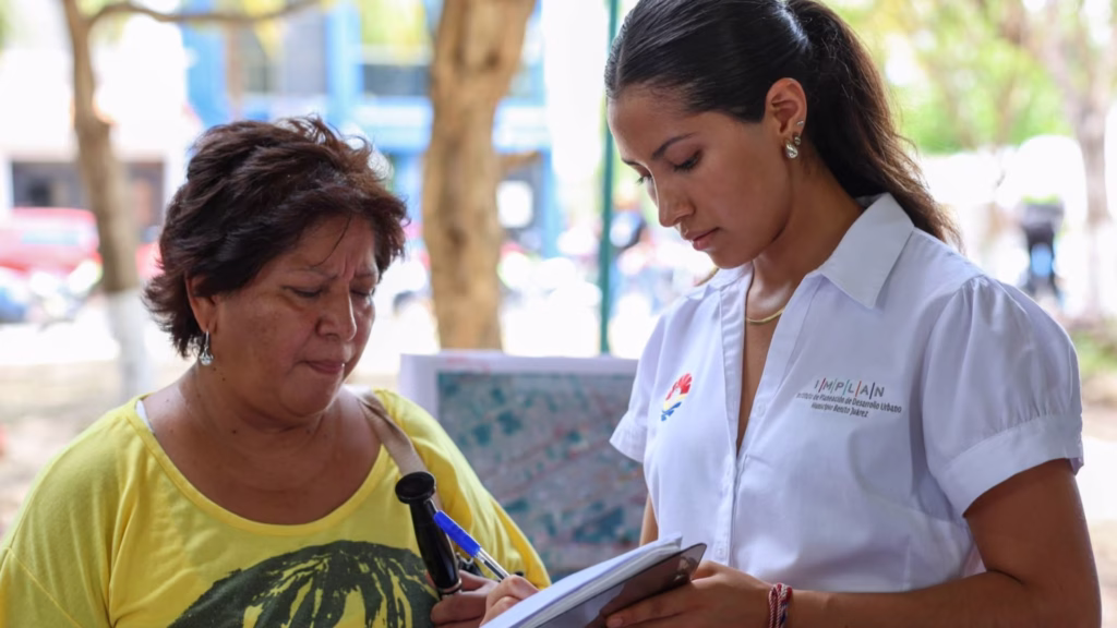 Servidor público atiende a un ciudadano durante la jornada de trámites municipales en Cancún.