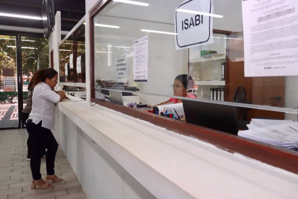 Ciudadana realiza trámite relacionado con el pago del impuesto predial en una oficina de atención municipal en Puerto Morelos.