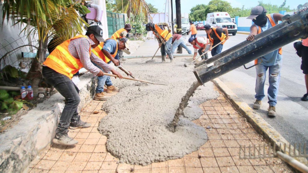 Construcción de banquetas durante obras de infraestructura y servicios públicos en Isla Mujeres.