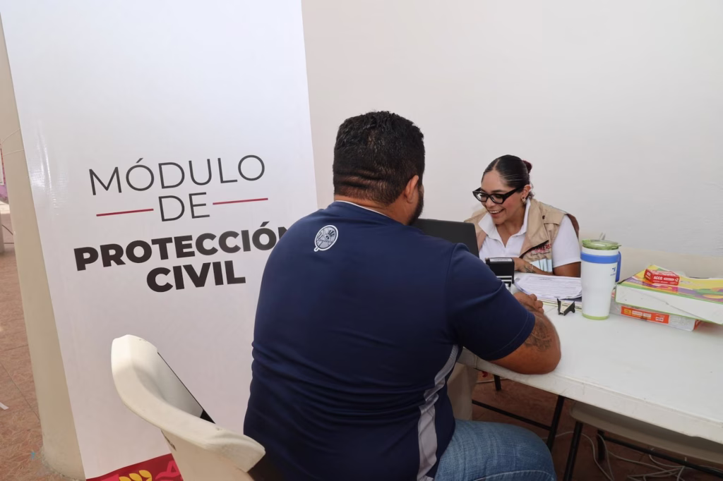 Ciudadano realiza trámites en el módulo de Protección Civil durante una jornada de regularización comercial en Isla Mujeres.
