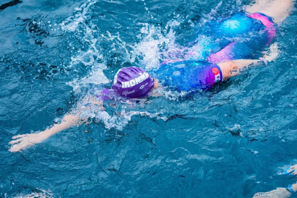 Competidores participan en la prueba de natación del Ironman Cozumel, uno de los principales eventos de turismo deportivo en Quintana Roo.