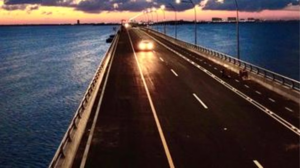Vista nocturna del Puente Nichupté con iluminación vial en Cancún.