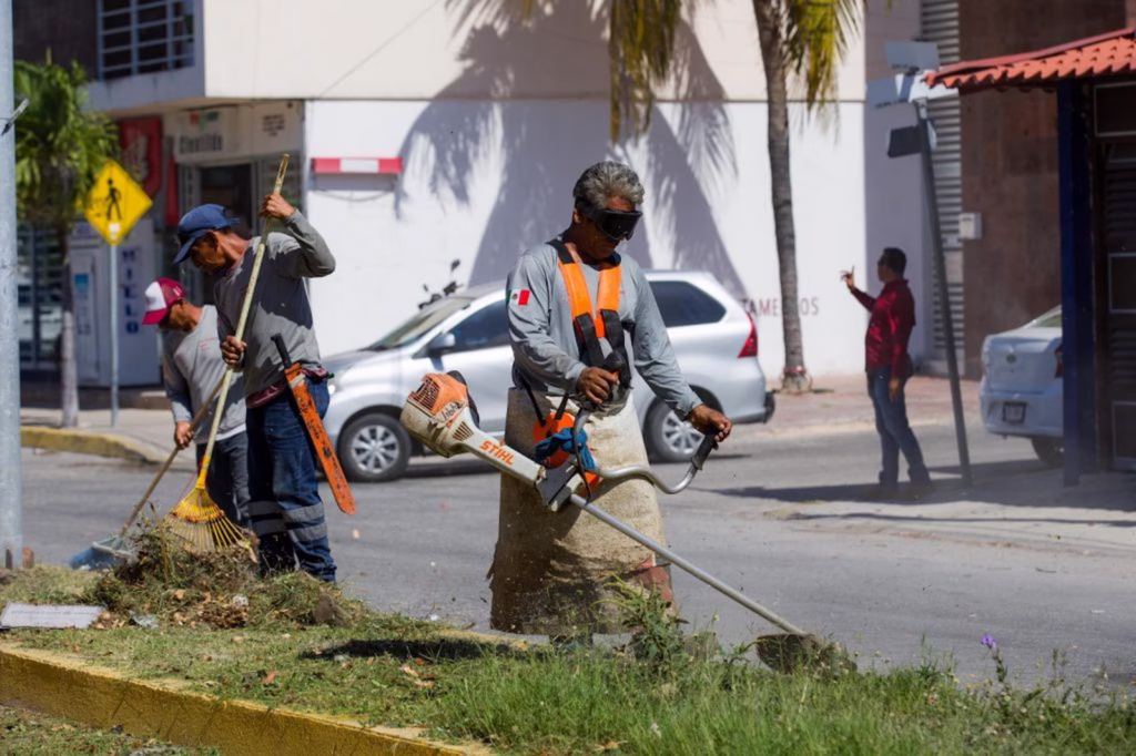 Personal de mantenimiento realiza trabajos en espacios públicos, actividad vinculada con los derechos laborales en Quintana Roo y las reformas laborales.