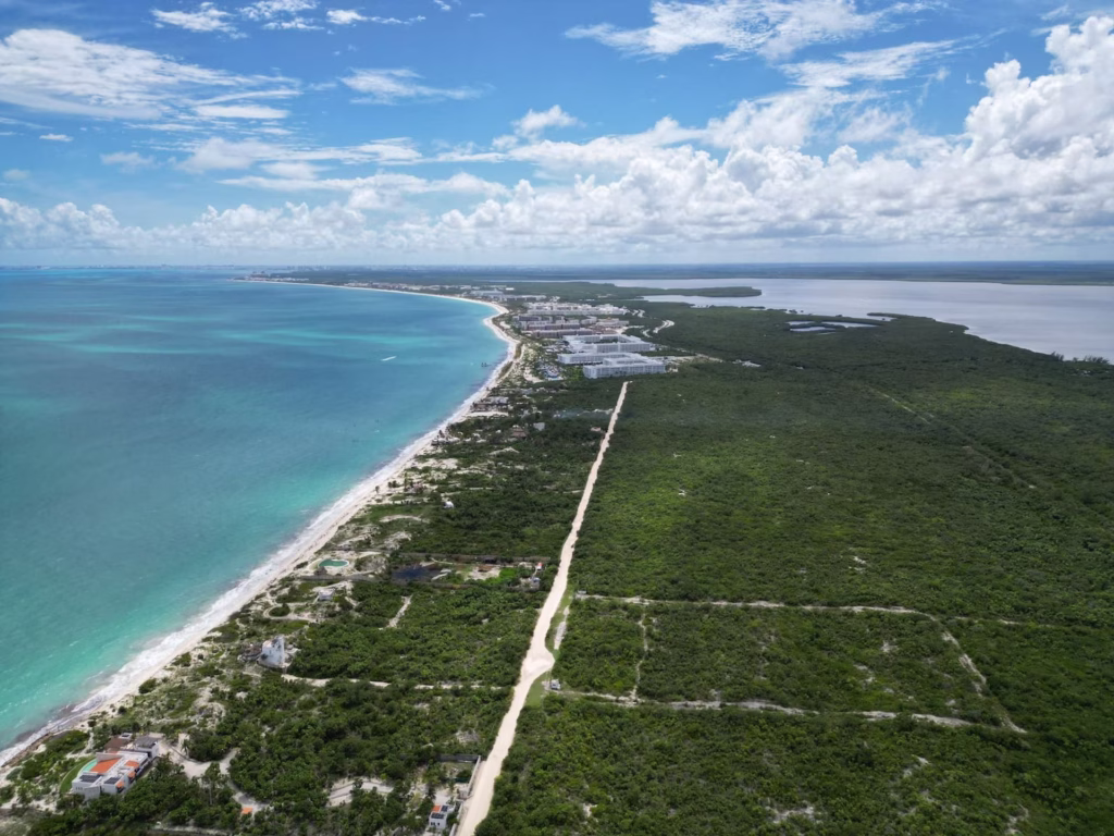 Vista aérea del crecimiento en Costa Mujeres con hoteles de lujo frente al Caribe mexicano.