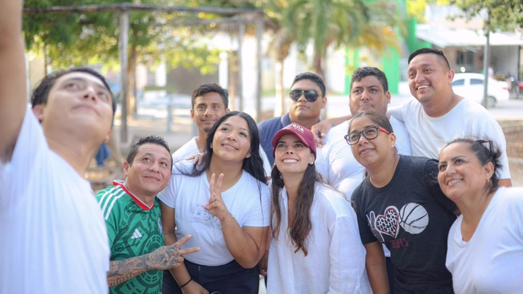 Ana Paty Peralta se fotografía con vecinos durante un recorrido en Tulum.