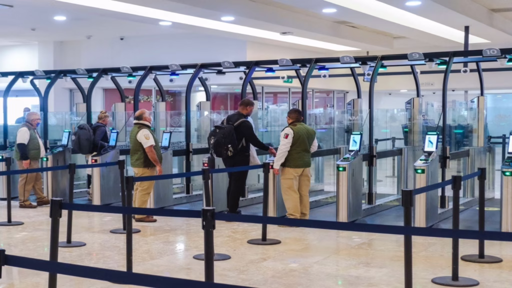 Filtros migratorios y módulos de atención para pasajeros internacionales en el aeropuerto de Cancún.