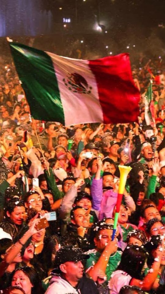 Aficionados mexicanos celebran con la bandera nacional después de que México está en octavos de final del Mundial 2026.
