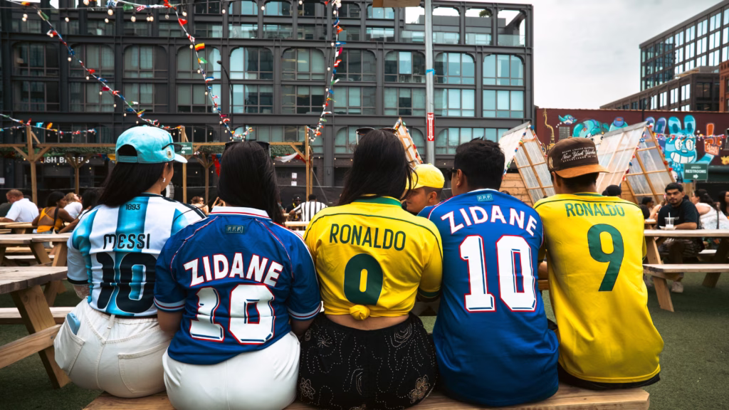 Aficionados con camisetas de futbol se reúnen en un establecimiento durante el Mundial 2026.