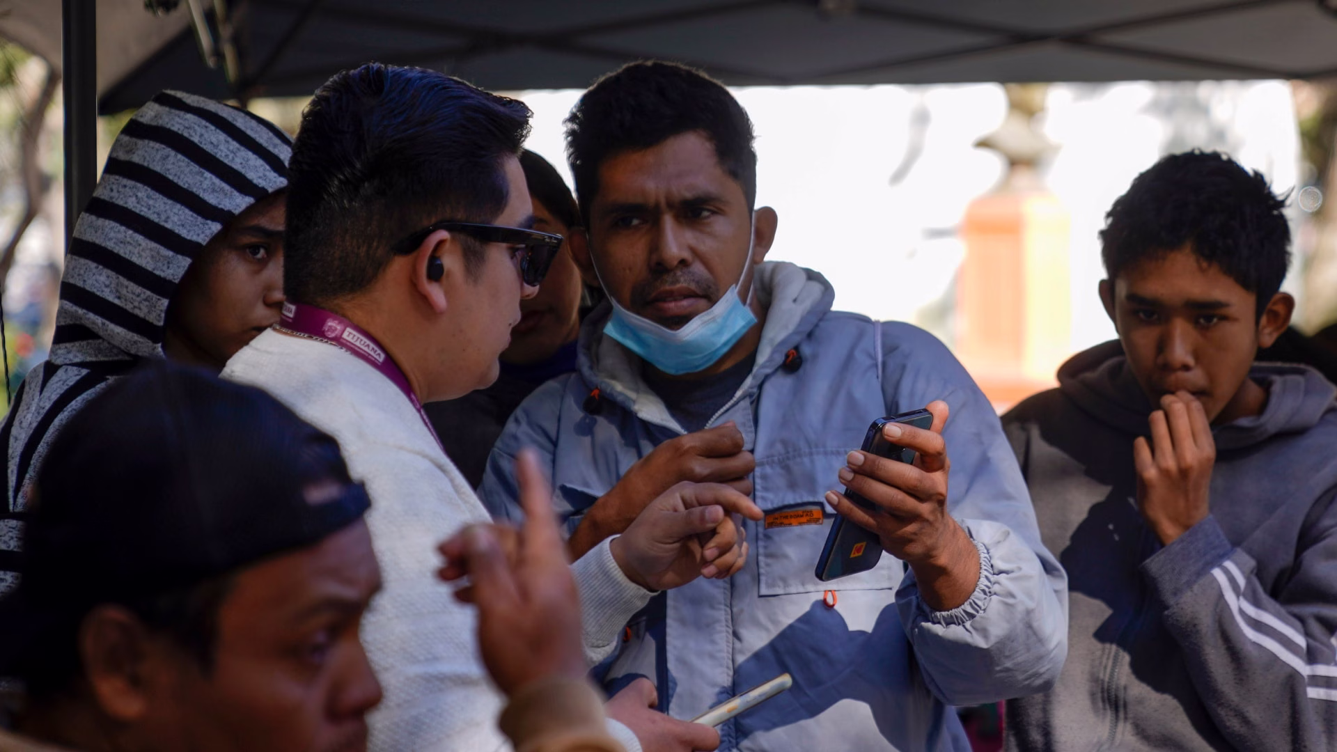 Personas consultan sus teléfonos celulares, dispositivos que podrán recibir alertas de huracanes mediante cobertura móvil.