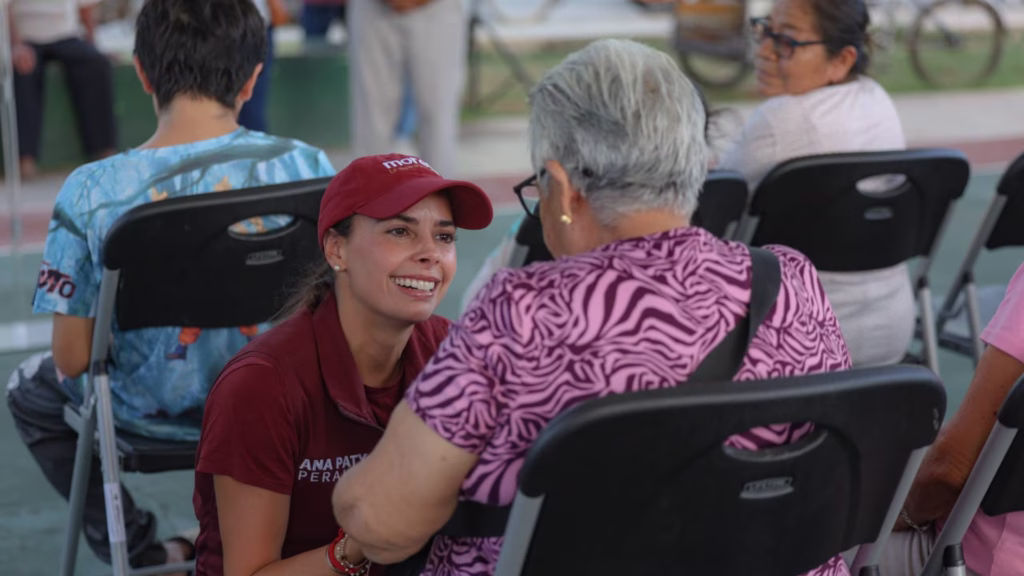 Ana Paty Peralta conversa con una habitante durante una asamblea realizada en Puerto Morelos