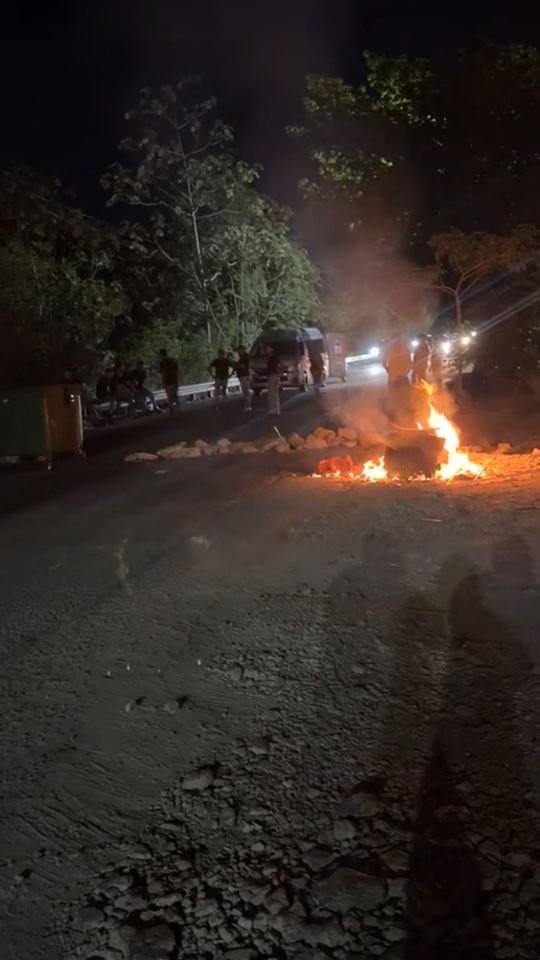 Fogata y manifestantes durante el bloqueo de la autopista El Tintal por los apagones en Playa del Carmen.