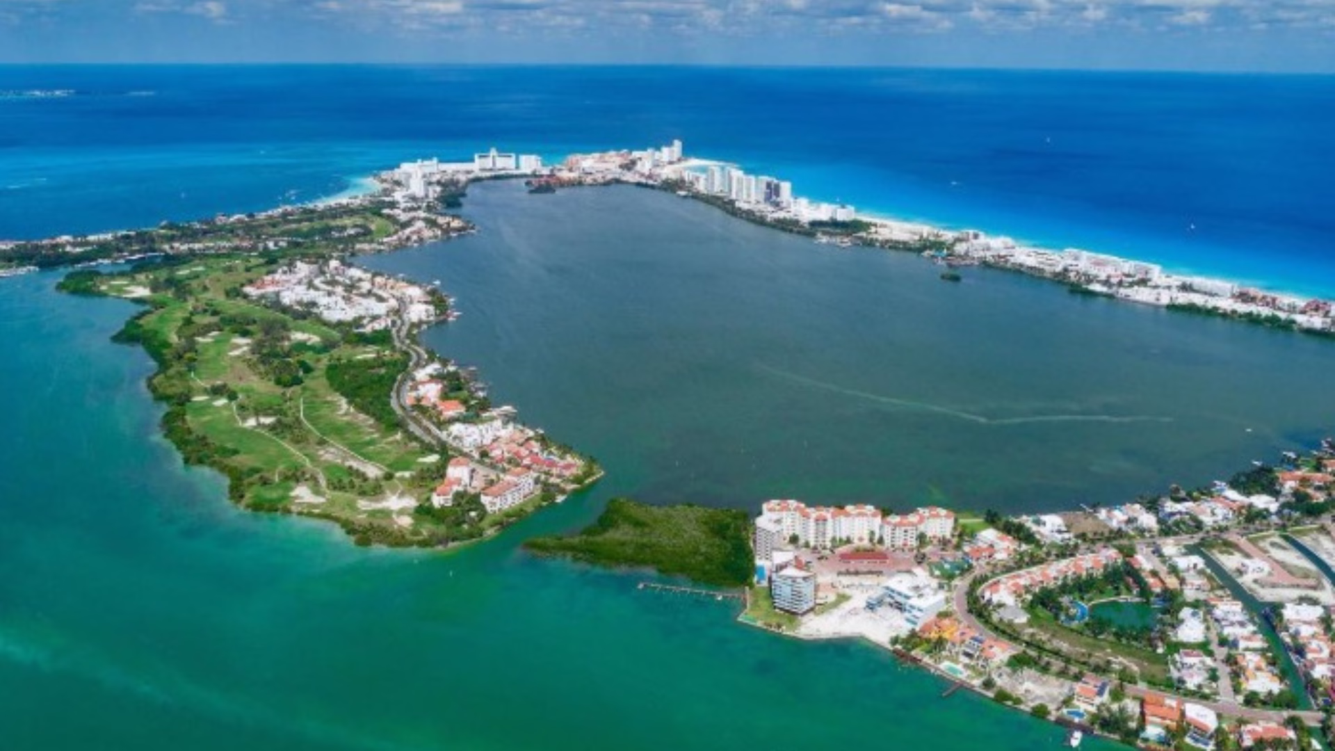 Vista aérea histórica del campo de golf Pok Ta Pok en operación, rodeado por la laguna Nichupté y la Zona Hotelera de Cancún.