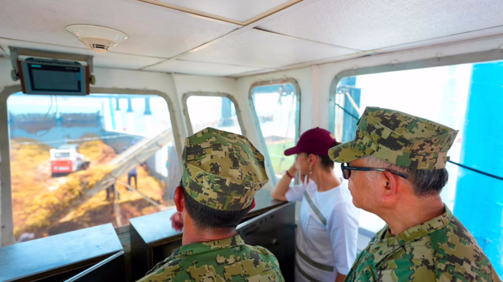 Claudia Sheinbaum y mandos de la Secretaría de Marina observan desde la cabina la operación de un buque sargacero.
