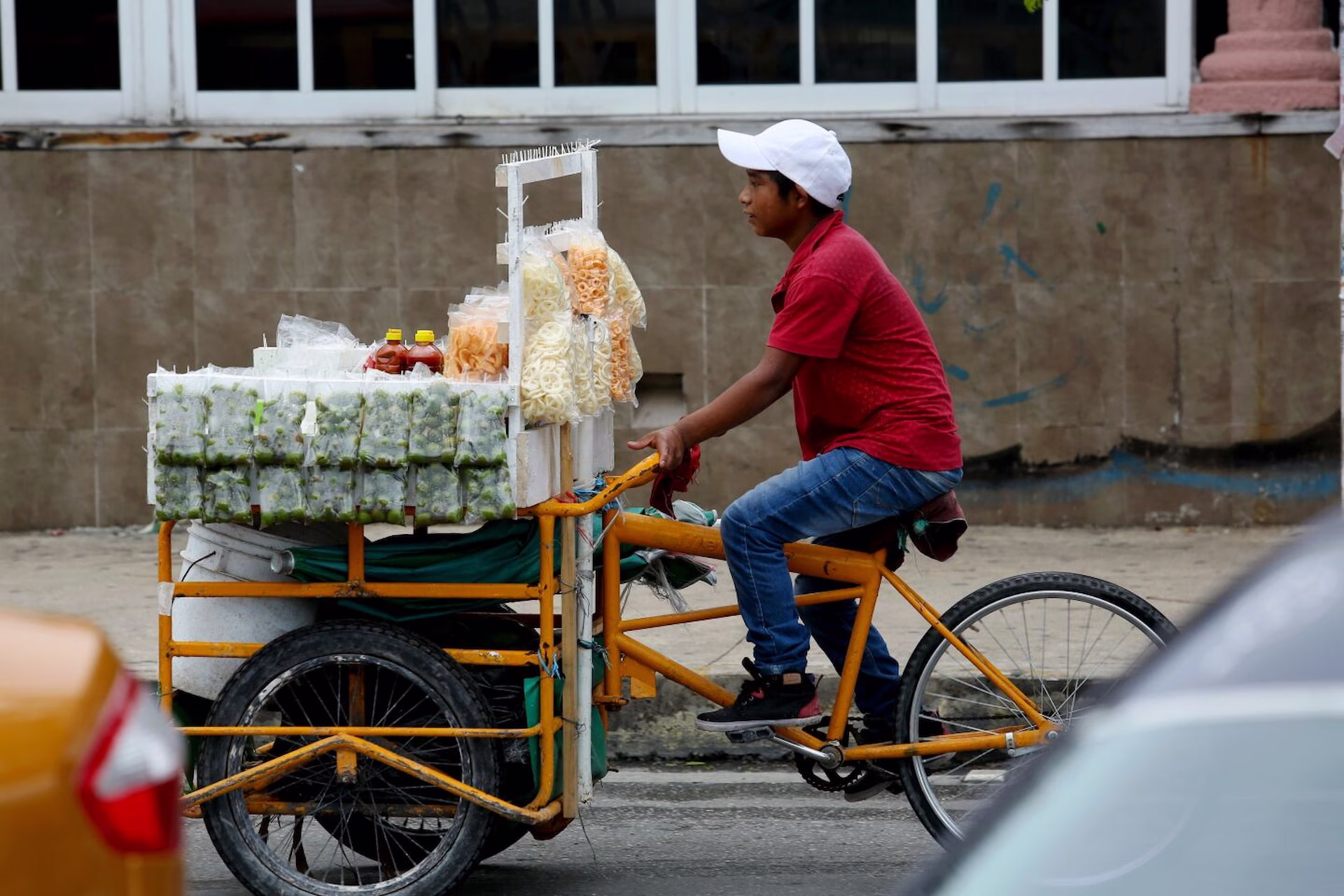 Vendedor ambulante transporta productos en un triciclo de carga como imagen de contexto sobre el comercio informal.