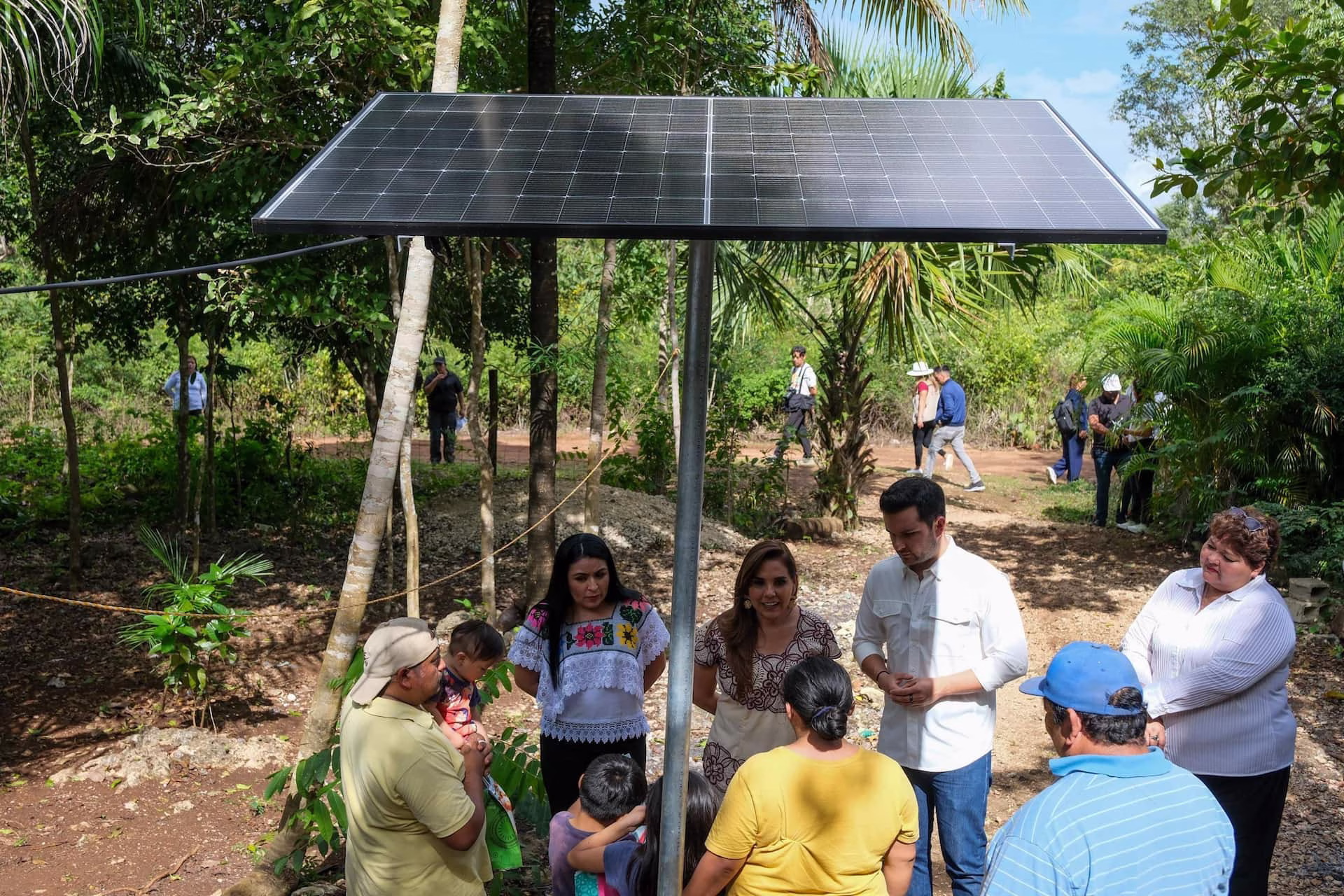 Habitantes participan en una actividad comunitaria junto a un sistema de paneles solares en Quintana Roo.