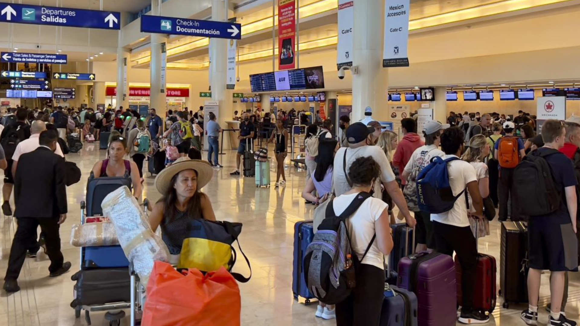 Pasajeros realizan el proceso de documentación en el Aeropuerto Internacional de Cancún.