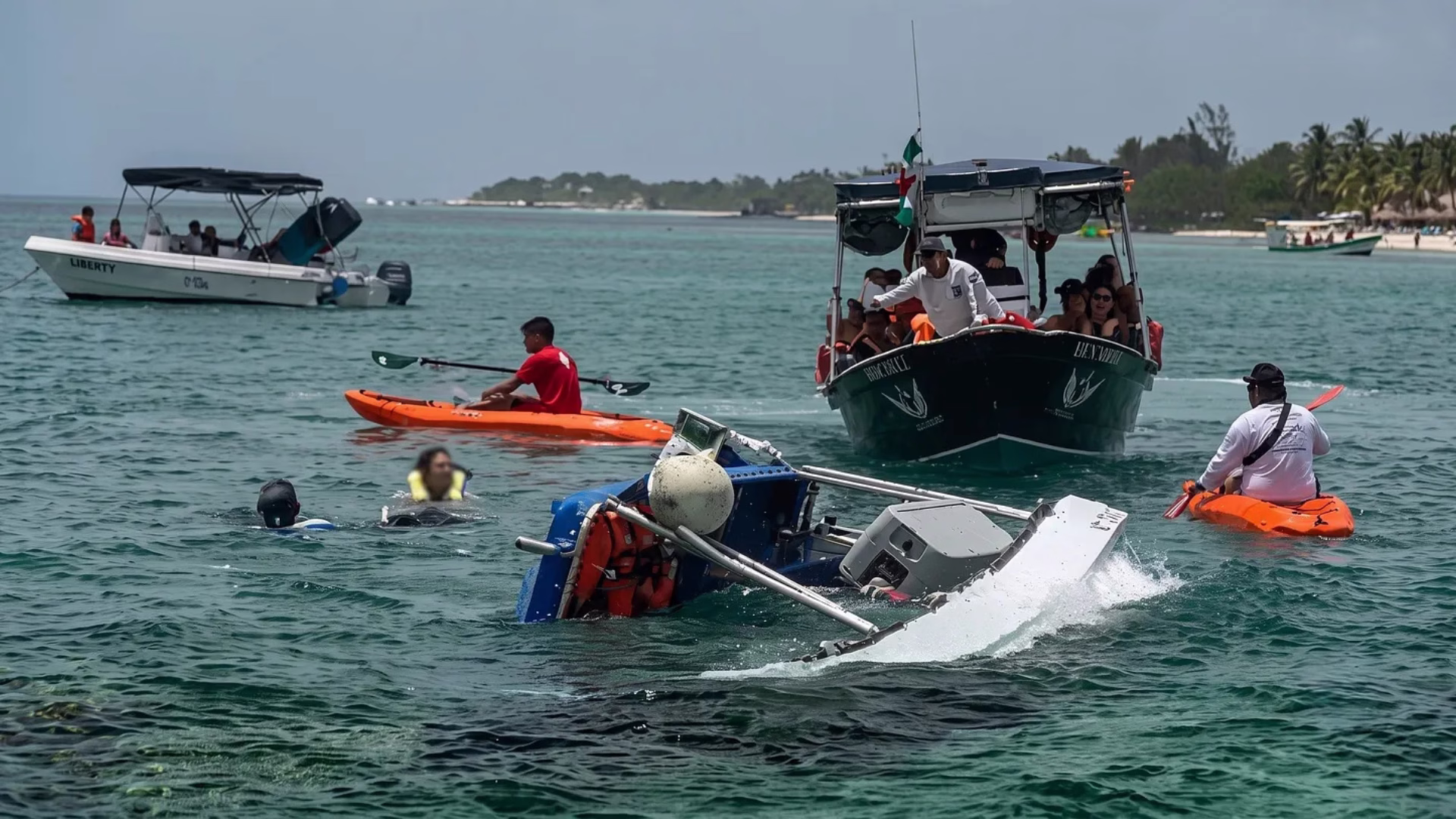 Embarcación parcialmente hundida mientras personas en kayaks y otras lanchas participan en las labores de auxilio.