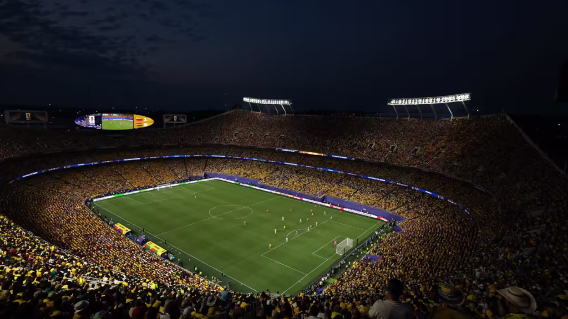 Vista panorámica nocturna de un estadio lleno durante un partido del Mundial 2026, con la cancha iluminada y las tribunas ocupadas.