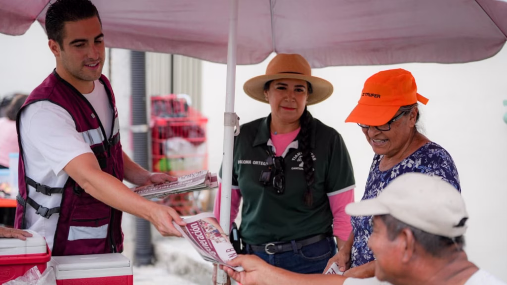 Gino Segura entrega un ejemplar de Regeneración durante su recorrido por un tianguis de Cancún