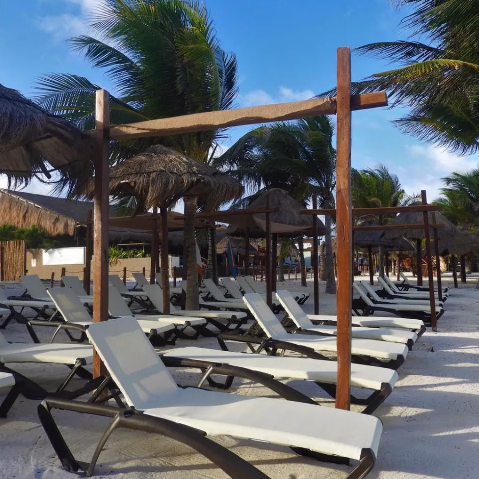 Área de descanso con camastros del Hotel Quinto Sole en Mahahual, ubicado frente al Caribe mexicano.