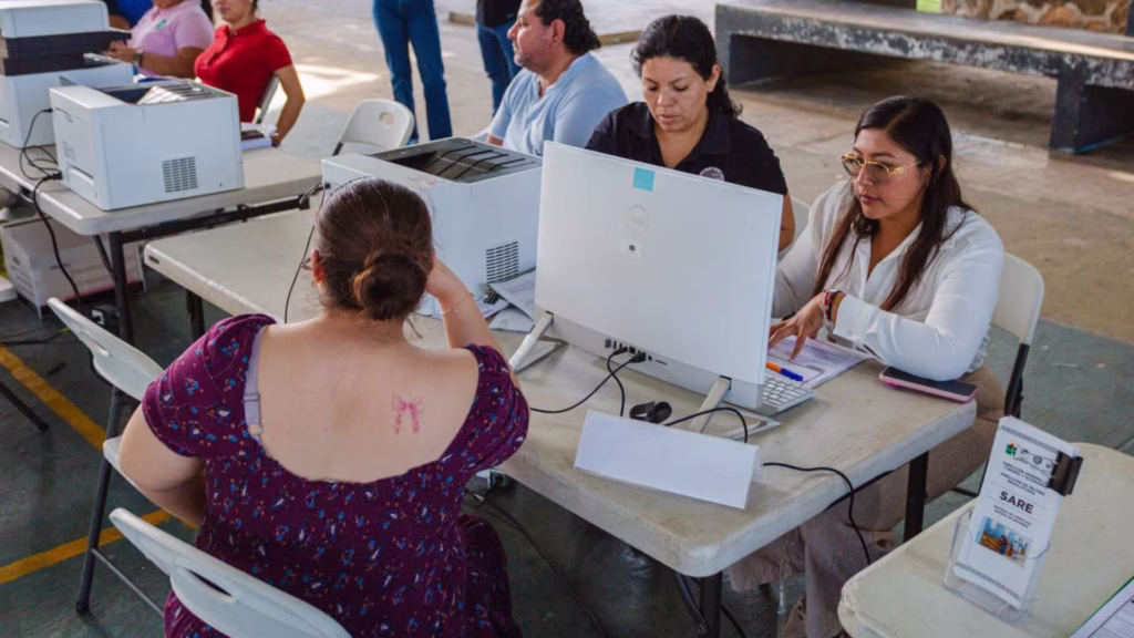 Personal atiende a una ciudadana en un módulo de servicios y trámites administrativos del municipio de Tulum.