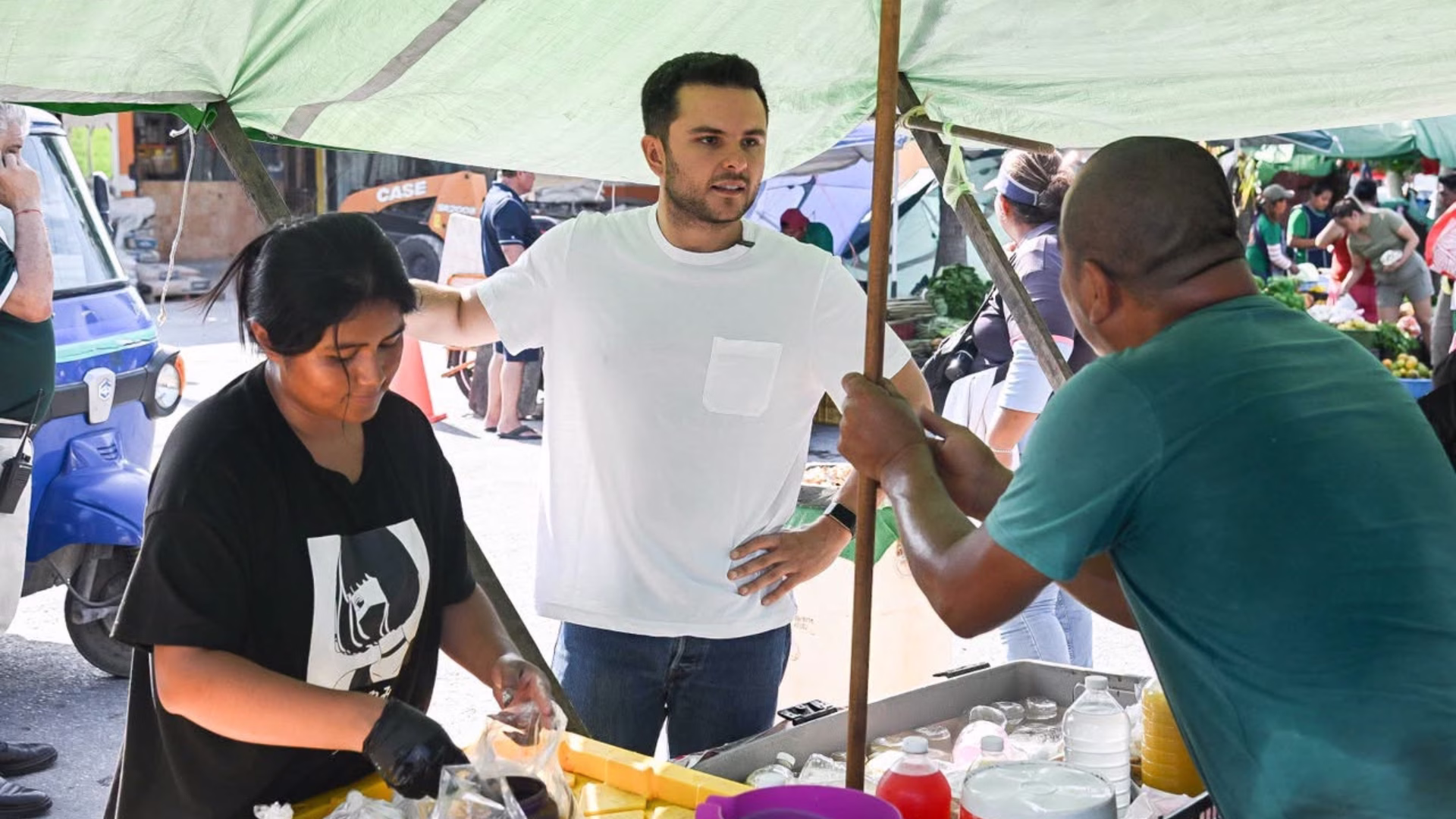 Pablo Bustamante en Cancún conversa con comerciantes durante un recorrido por un tianguis de la ciudad.