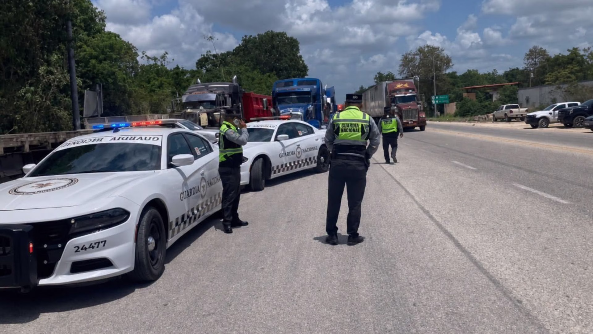 Unidades de seguridad y personal vial acompañan la movilización de transportistas en Tulum sobre la carretera federal 307.