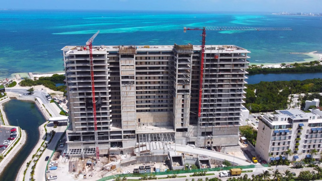 Edificio de gran altura en construcción junto al litoral de Quintana Roo, sector que depende de acero, aluminio, maquinaria y otros insumos.