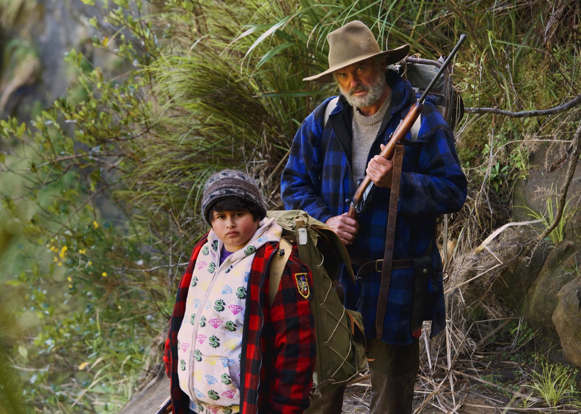 Sam Neill y Julian Dennison recorren el bosque en Hunt for the Wilderpeople, una de sus películas más reconocidas en Nueva Zelanda.