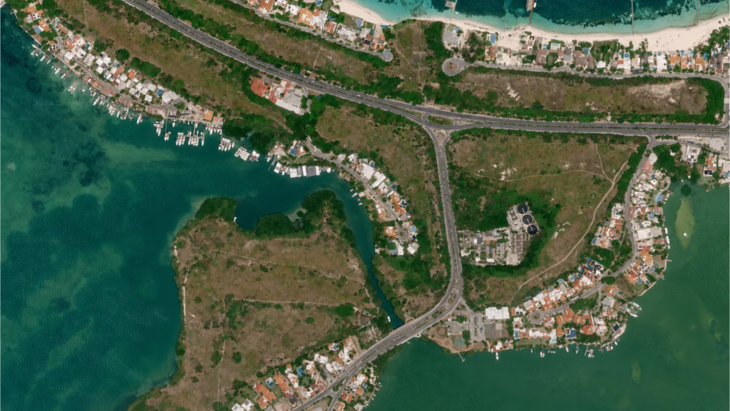 Vista panorámica de los terrenos de Pok Ta Pok entre zonas residenciales, vialidades, playas y la laguna Nichupté en Cancún.