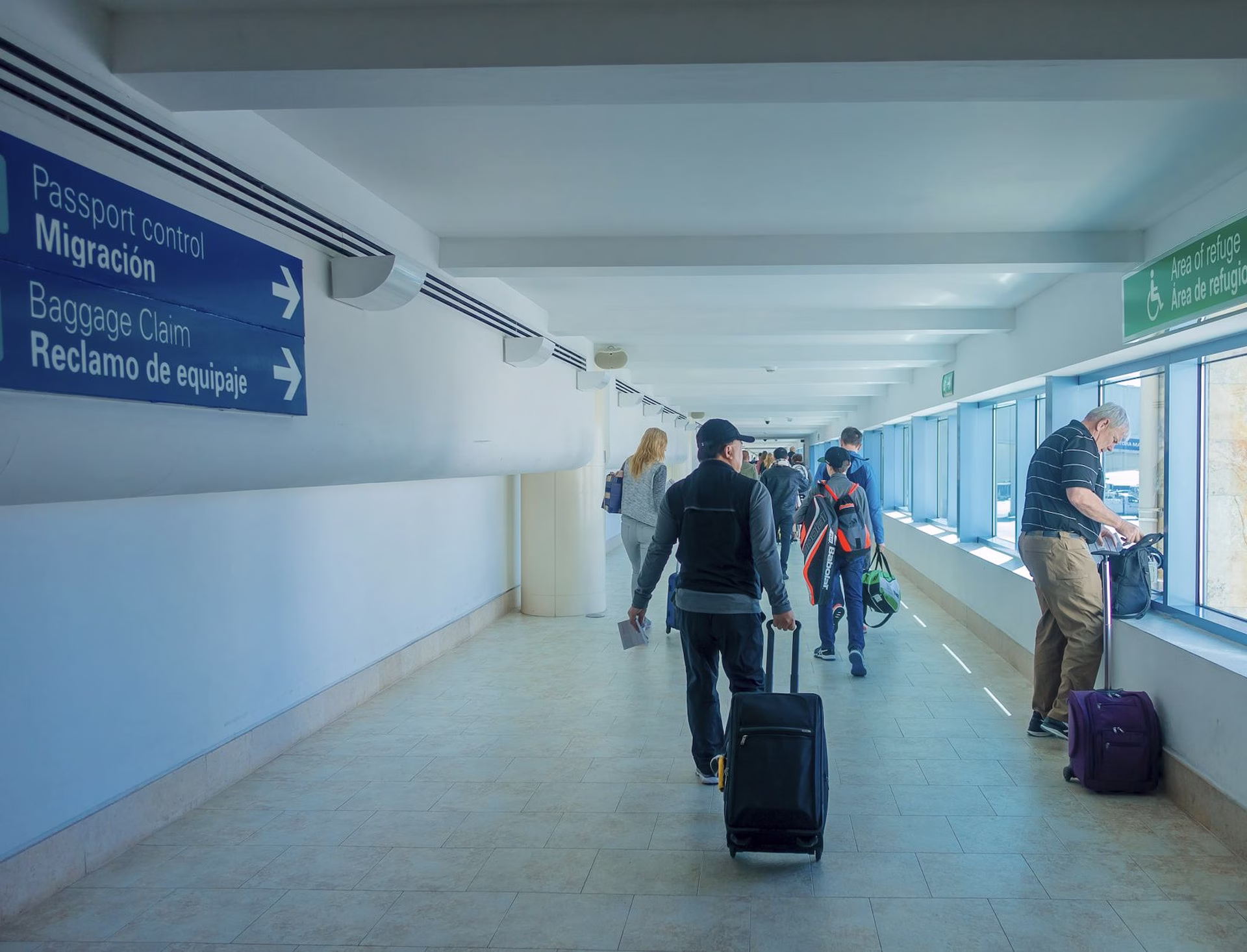 Viajeros recorren uno de los pasillos del Aeropuerto Internacional de Cancún con equipaje.