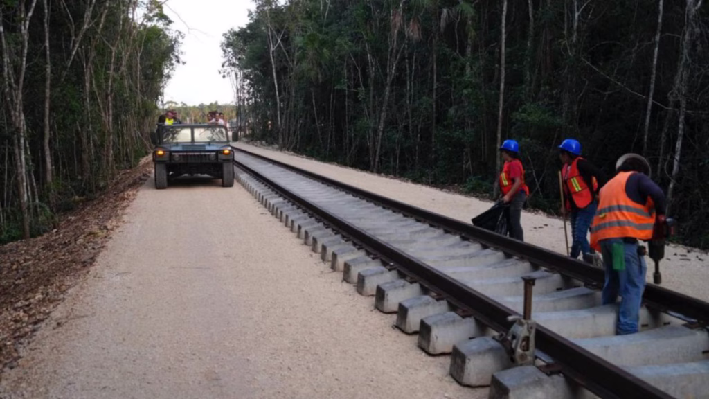 Personal realiza trabajos de mantenimiento en las vías del Tren Maya en un tramo rodeado de selva.