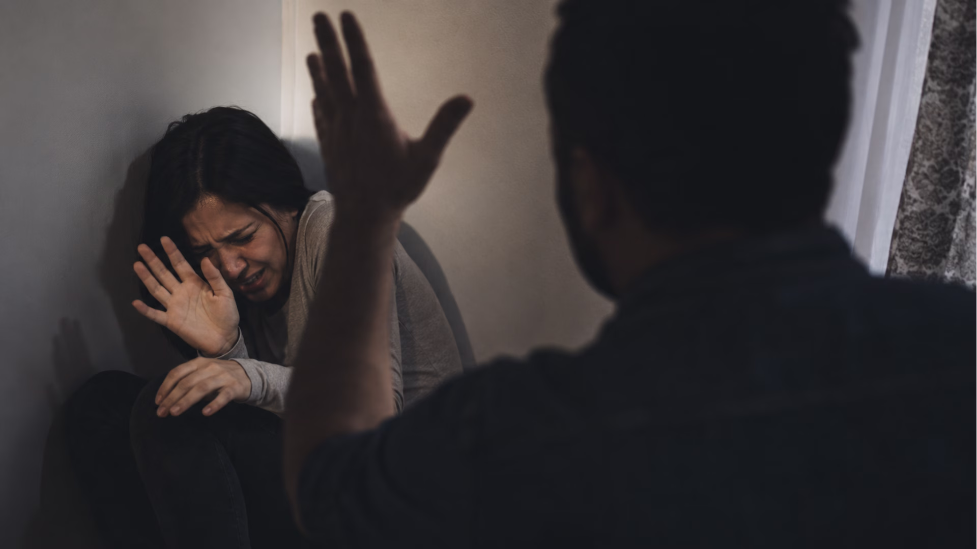 Mujer víctima de violencia familiar intenta protegerse ante una agresión en una imagen conceptual realista