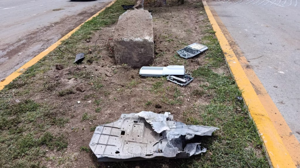 Restos de infraestructura y piezas de un vehículo sobre el camellón de la avenida Bonampak tras un accidente.