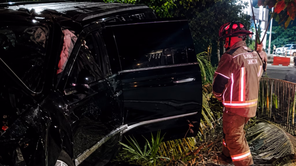 Bombero de Cancún junto a la camioneta accidentada en el bulevar Kukulcán.