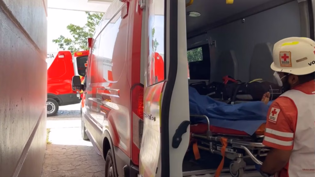 Paramédico de la Cruz Roja junto a una persona trasladada en ambulancia durante un operativo de emergencia.