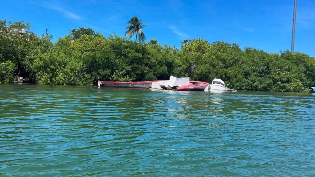 Una embarcación permanece parcialmente sumergida en un canal de Cancún.