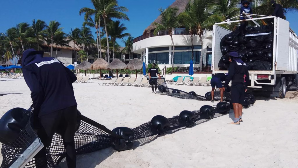 Elementos de la Marina movilizan una barrera antisargazo durante los trabajos realizados en Playa del Carmen.