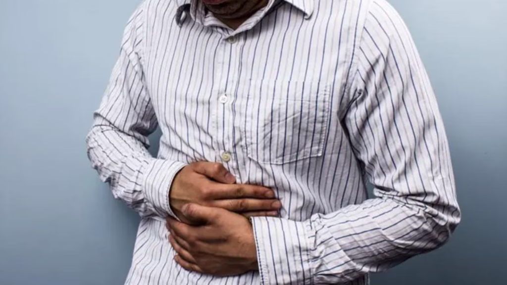 Persona con malestar abdominal, uno de los posibles síntomas asociados con la ciclosporiasis.