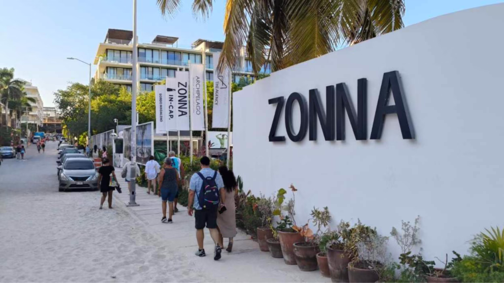 Muro con el nombre ZONNA junto a una calle de Playa del Carmen