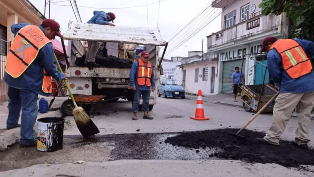 Trabajadores realizan labores de bacheo y mantenimiento en una calle