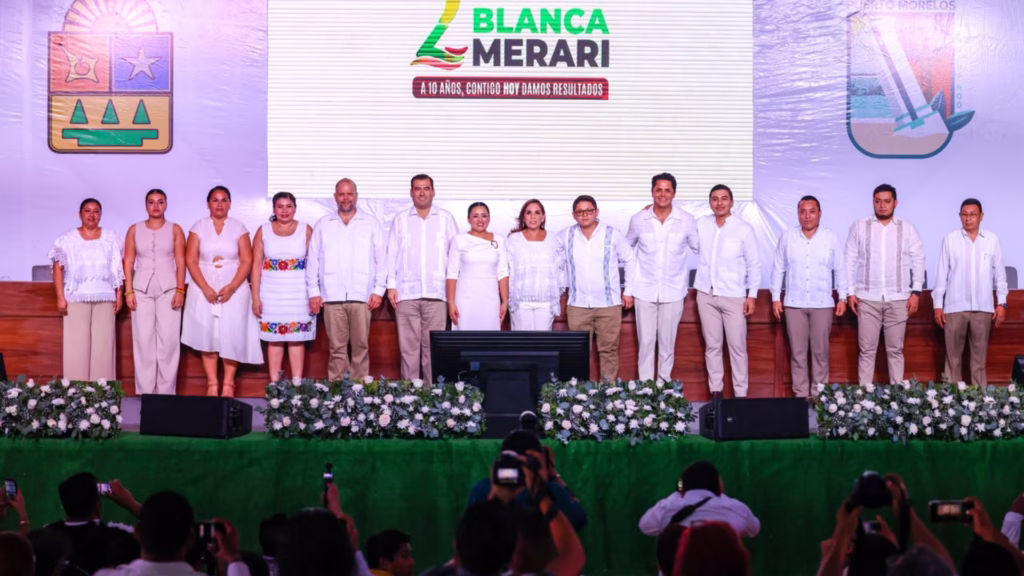 Integrantes del Cabildo y autoridades posan en el escenario durante el Segundo Informe de Gobierno de Puerto Morelos.