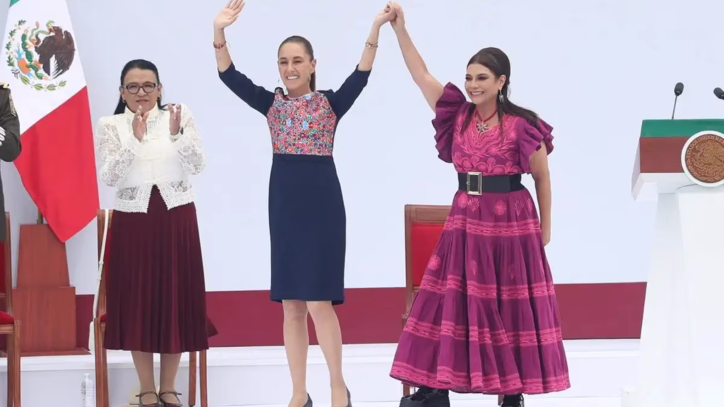 Claudia Sheinbaum y Clara Brugada levantan las manos durante un acto en el Zócalo