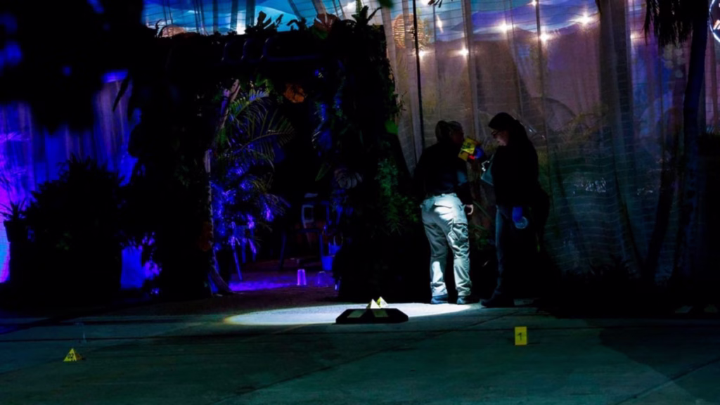 Personal pericial trabaja de noche en una escena acordonada con indicios numerados