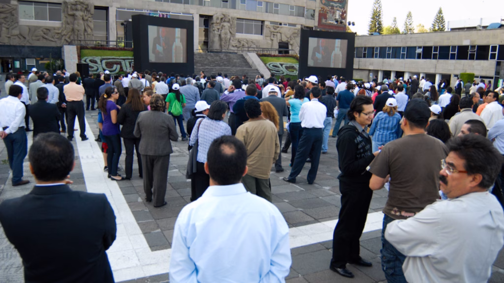 Trabajadores y asistentes siguen la transmisión del lanzamiento del Satélite Bicentenario