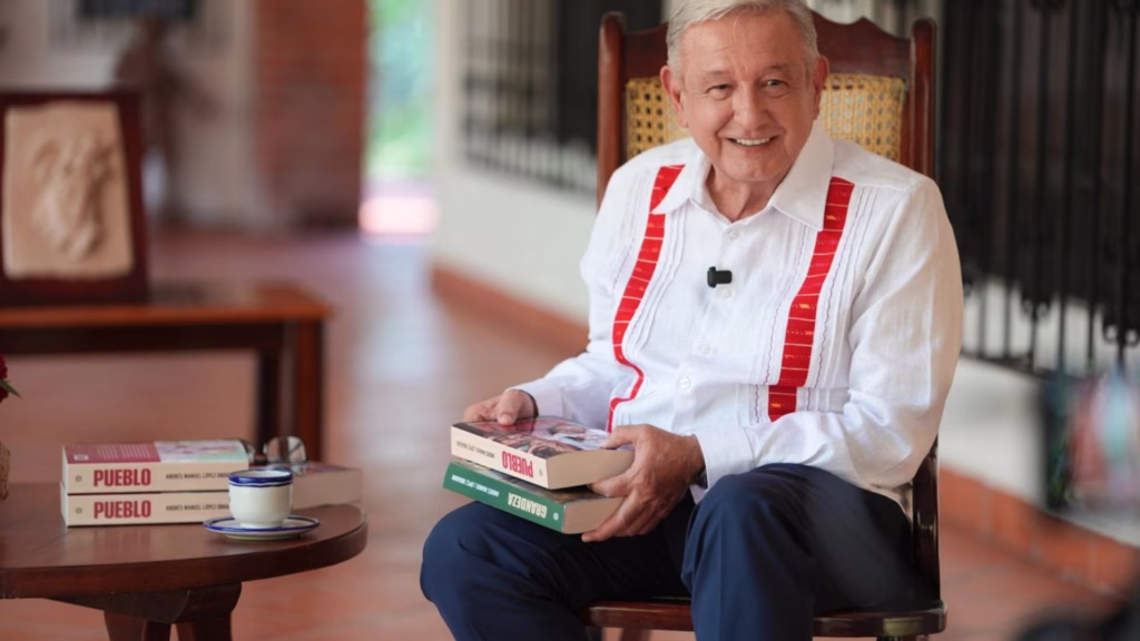 Andrés Manuel López Obrador sostiene ejemplares de sus libros durante su retiro en Palenque