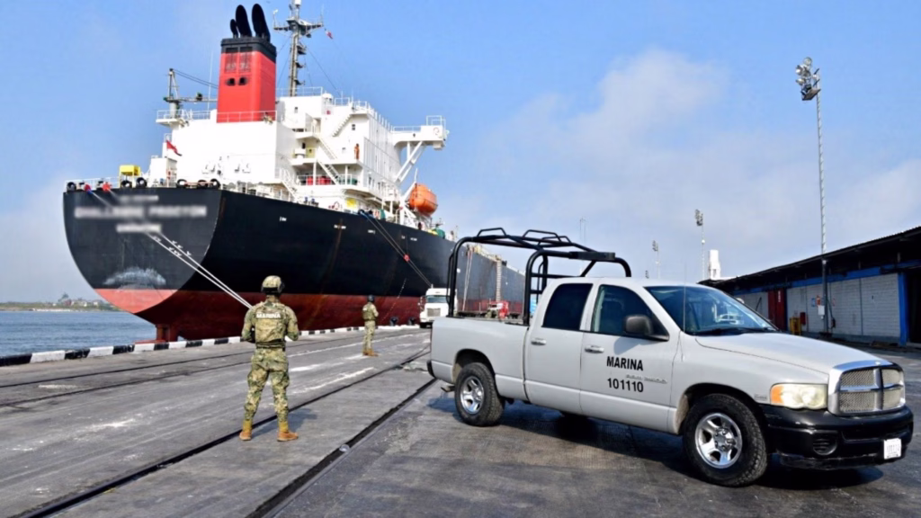 Personal de la Secretaría de Marina custodia un buque atracado en una terminal portuaria de México.