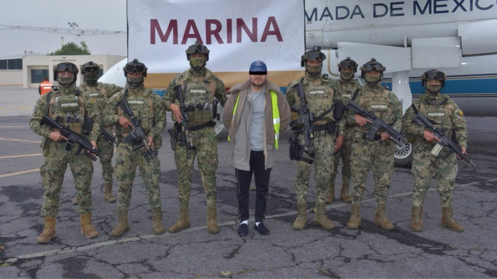 Persona detenida permanece rodeada por elementos de la Secretaría de Marina durante un operativo.